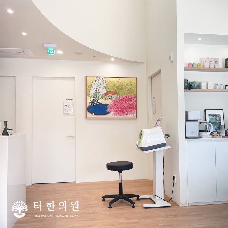 진료실 문과 그림, 의료기기가 보이는 한의원 내부